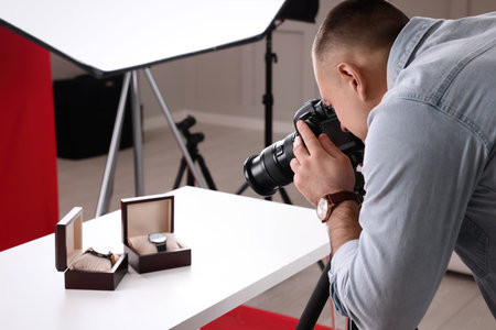 Professional photographer taking picture of expensive wristwatches in studioの写真素材