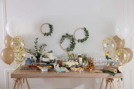 Beautiful cake and other treats on table in room. baby shower party