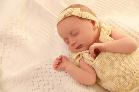 Adorable newborn baby sleeping on knitted plaid