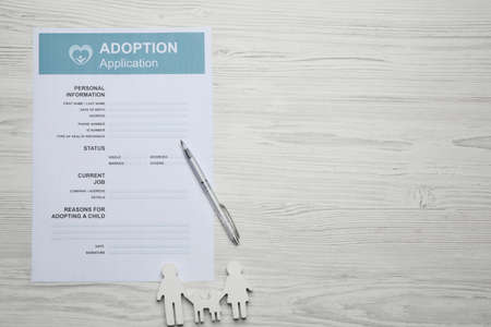 Adoption application, family figure and pen on white wooden table, flat lay. Space for textの写真素材