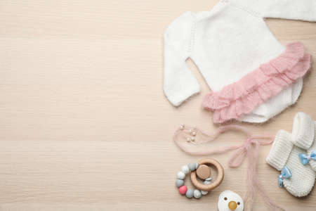 Cute baby stuff on wooden background, flat lay. Space for textの写真素材