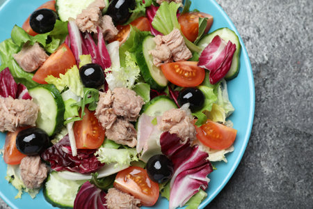 Plate of delicious salad with canned tuna and vegetables on gray table, top viewの写真素材