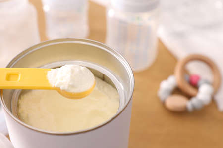 Can of powdered infant formula with scoop on table, closeup. baby milkの写真素材