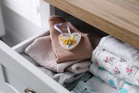 Beautiful heart shaped scented wax sachet and clothes in dresser drawer indoors, closeupの写真素材
