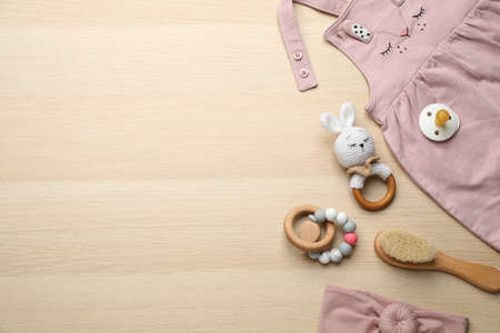 Cute baby stuff on wooden background, flat lay. Space for textの写真素材