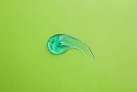Smear of ointment on light green background, top view
