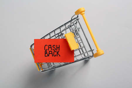Card with word Cashback in shopping cart on light gray background, top viewの写真素材