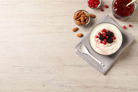 Delicious semolina pudding with berries on wooden table, flat lay. Space for textの写真素材