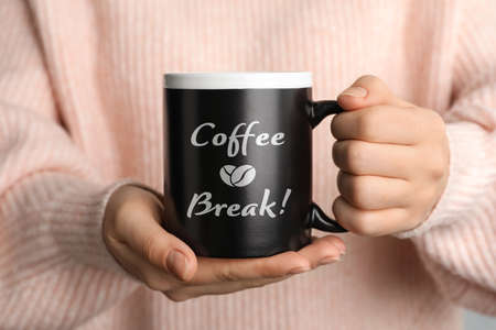 Woman holding mug with inscription Coffee Break, closeup