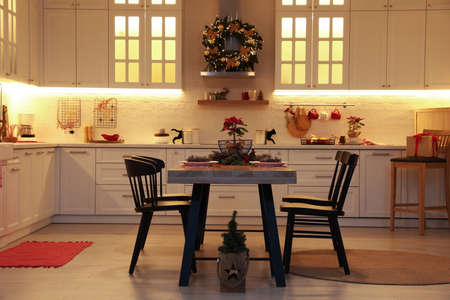 Cozy dining room interior with beautiful Christmas wreath and festive decorの写真素材