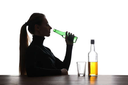 alcohol addiction. Woman drinking beer on white backgroundの写真素材