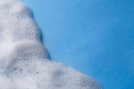 White foam on light blue background. Space for text