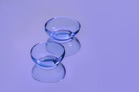 Pair of contact lenses on violet reflective surfaceの写真素材