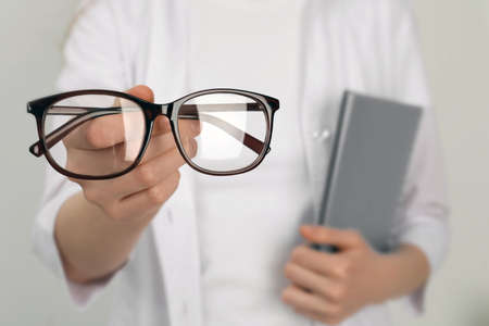 Woman with glasses on light background, closeupの写真素材