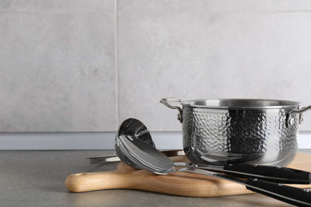 Set of different cooking utensils on gray countertop in kitchen. Space for text