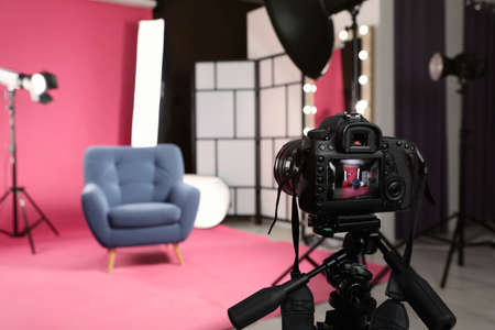 Stylish blue armchair in photo studio with professional equipment, focus on cameraの写真素材
