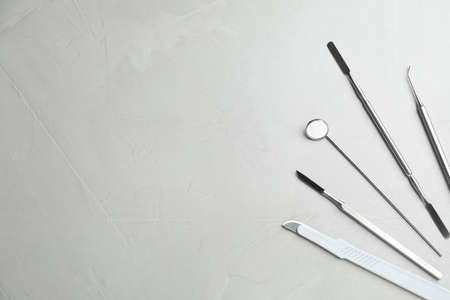 Set of different dentist's tools on light gray table, flat lay. Space for textの写真素材