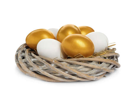 Nest with golden and ordinary chicken eggs on white backgroundの写真素材