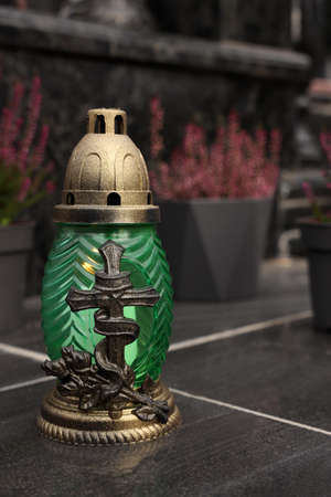 Grave lantern on black tiled surface at cemetery