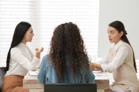 African American woman and her coworkers in office, back view. Racism at workの写真素材