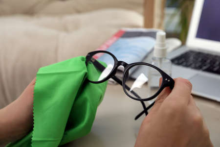 Woman cleaning glasses with microfiber cloth at home, closeupの写真素材