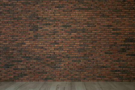 Empty room with red brick wall and wooden floorの写真素材