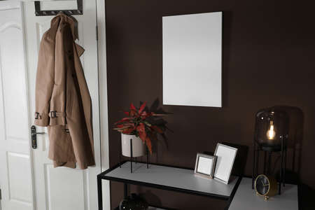 Stylish hallway interior with empty canvas on brown wall. Mockup for designの写真素材