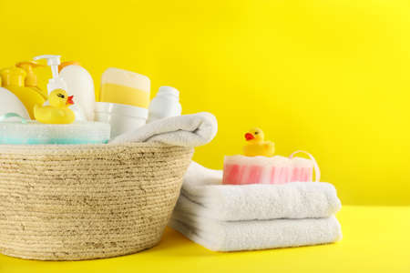 Basket with baby cosmetic products and accessories on yellow backgroundの写真素材