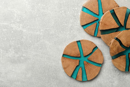 Stylish wooden cup coasters on light gray table, flat lay. Space for textの写真素材