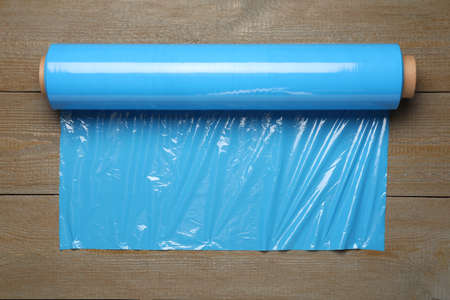 Roll of plastic stretch wrap film on wooden table, top viewの写真素材