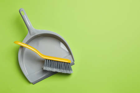 Plastic hand broom and dustpan on light green background, top view. Space for textの写真素材