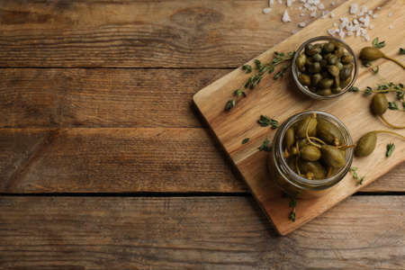Tasty capers on wooden table, top view. Space for textの写真素材