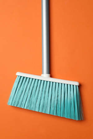 Plastic broom on orange background, top viewの写真素材