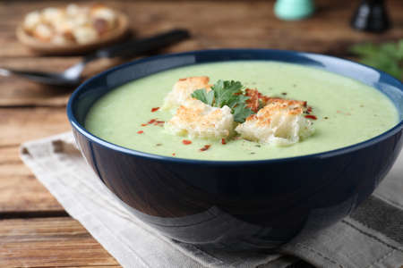 Delicious asparagus soup with croutons served on wooden table, closeupの写真素材