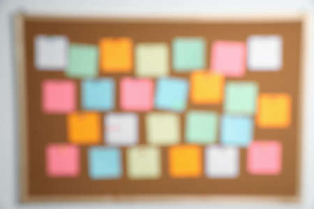 Blurred view of cork board with many colorful notesの写真素材