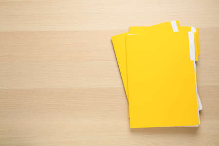 Yellow files with documents on wooden table, top view. Space for textの写真素材
