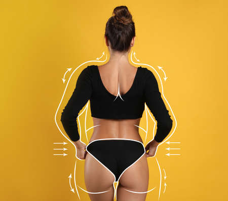 Slim woman after weight loss on yellow background, back viewの写真素材