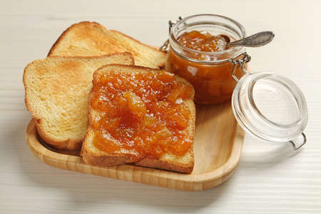 Delicious toasts with jam served on white wooden table, closeup