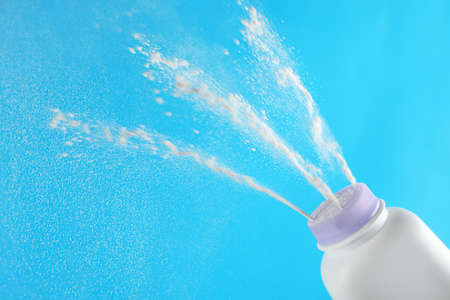 Scattering of dusting powder on light blue backgroundの写真素材