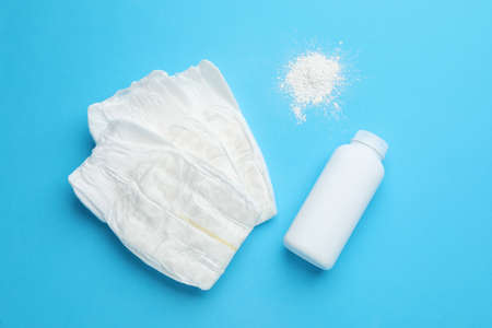 Dusting powder and diapers on light blue background, flat lay. baby care productsの写真素材