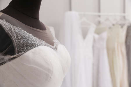 Mannequin with beautiful wedding dress in atelier, closeup. Space for textの写真素材