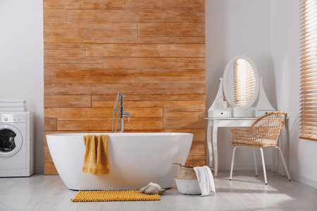 Soft orange mat and slippers on floor near tub in bathroom. interior designの写真素材