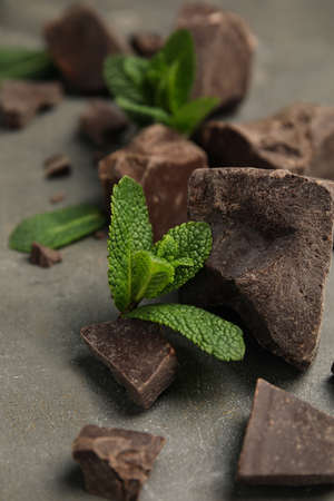 Tasty dark chocolate pieces with mint on gray table, closeupの写真素材
