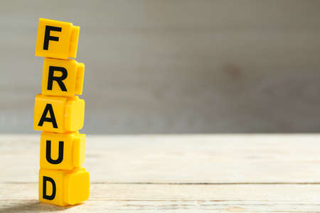 Word Fraud of yellow cubes with letters on white wooden background. Space for textの写真素材