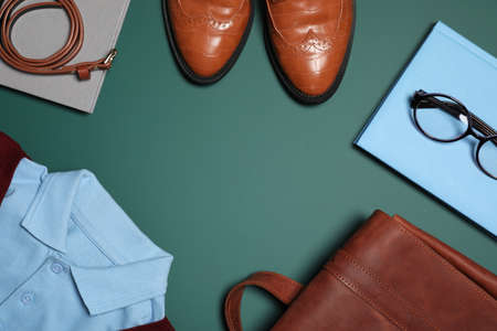 Stylish school uniform, glasses and notebook on green background, flat lay. Space for textの写真素材
