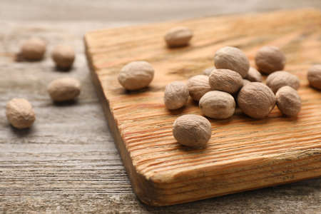 Nutmeg seeds on wooden table, closeup. Space for textの写真素材