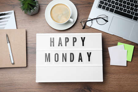 Light box with message Happy Monday, office stationery and cup of coffee on wooden desk, flat layの写真素材