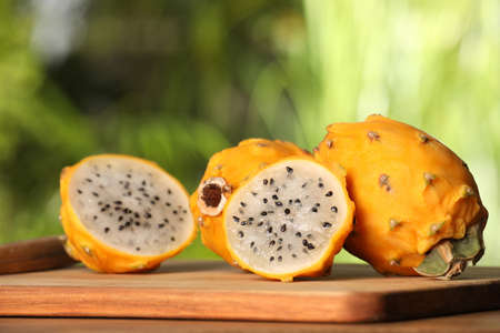 Delicious cut and whole dragon fruits (pitahaya) on wooden tableの写真素材