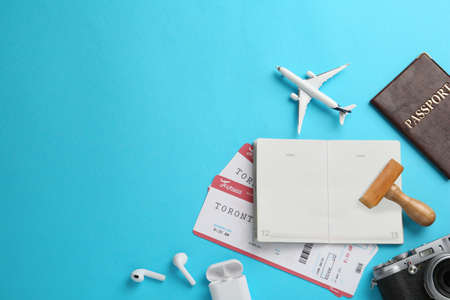 Flat lay composition with passports, stamp and flight tickets on light blue background, space for...