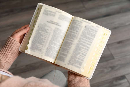 Above view of woman reading Bible indoors, closeup
